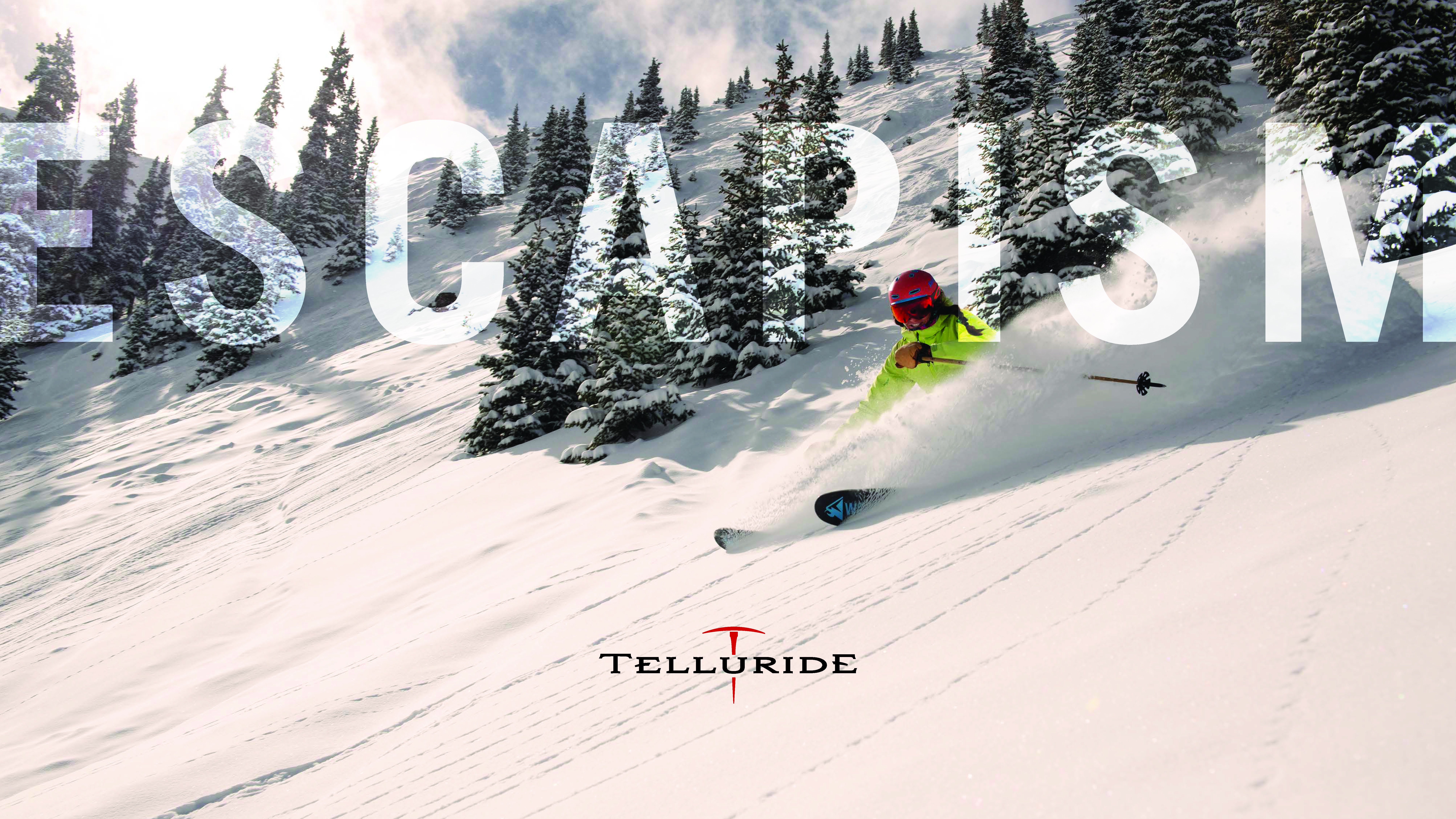 Escapism spread - skier with bright yellow jacket spraying powder